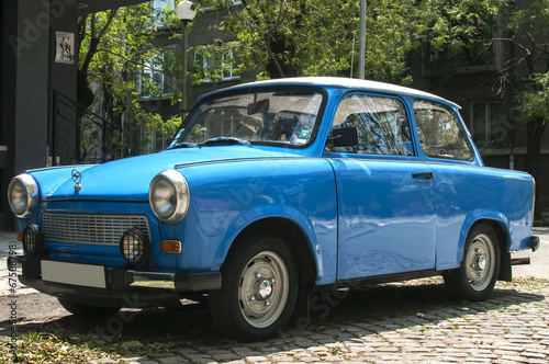 Платно Blue vintage restored Trabant car on paved street