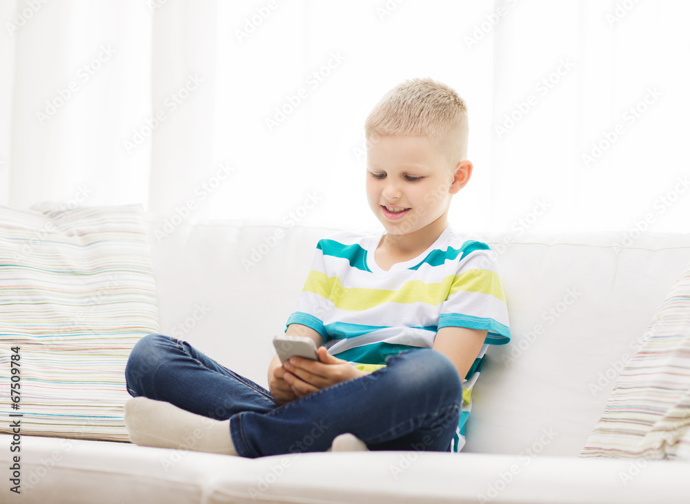 smiling little boy with smartphone at home smiling little boy with smartphone at home