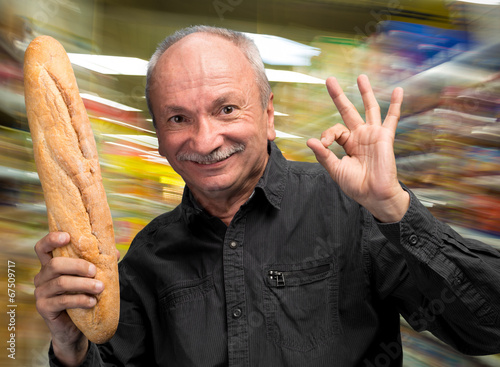 Happy senior man holding fresh baguette photo