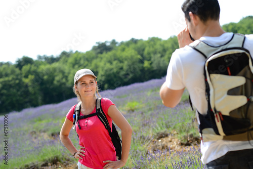 young man taking picture of girlfriend trekking summer vacation