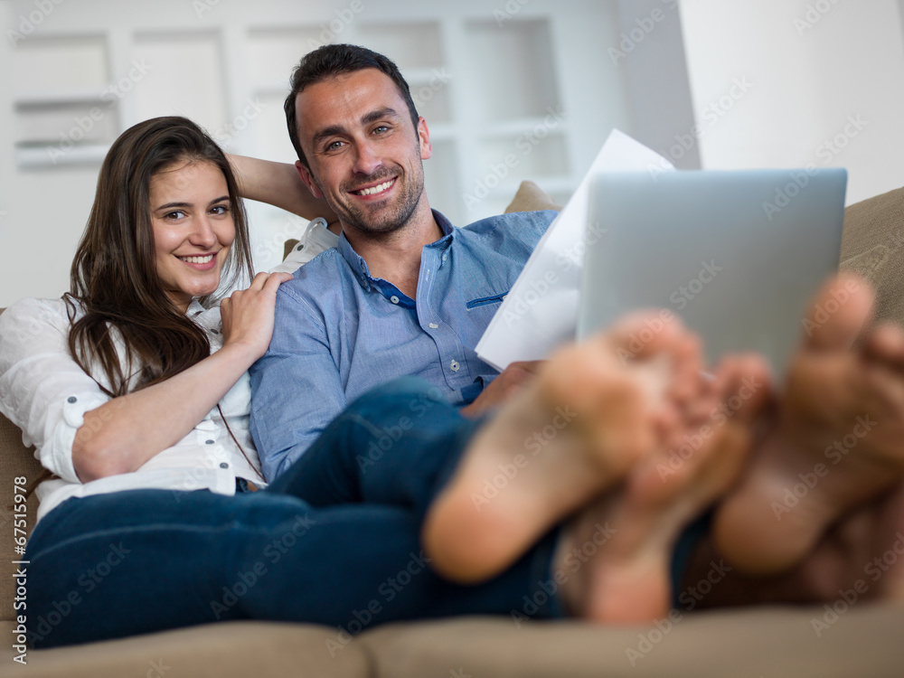 relaxed young couple working on laptop computer at home relaxed young couple working on laptop computer at home