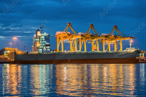Container Cargo freight ship with working Container crane in shi
