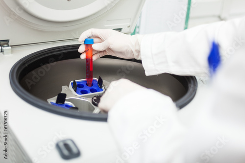Scientist using a laboratory centrifuge