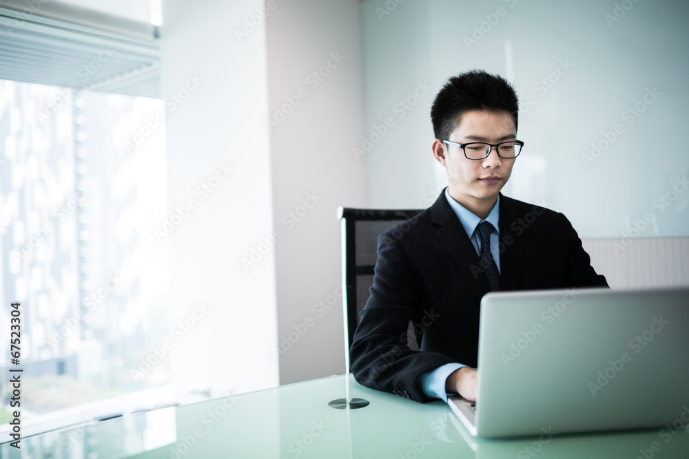 Young handsome man using laptop in his office Young handsome man using laptop in his office