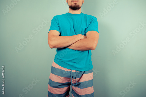 Young man in striped shorts with arms crossed