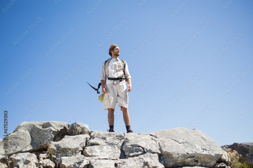 Obraz premium Handsome hiker standing at the summit looking around