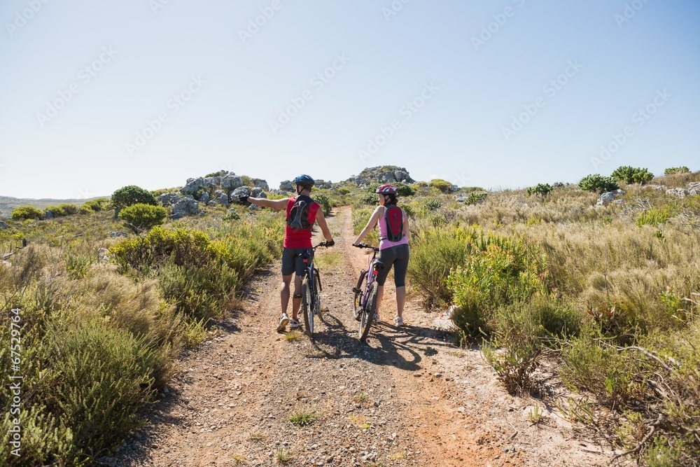 Active couple cycling in the countryside looking to the side