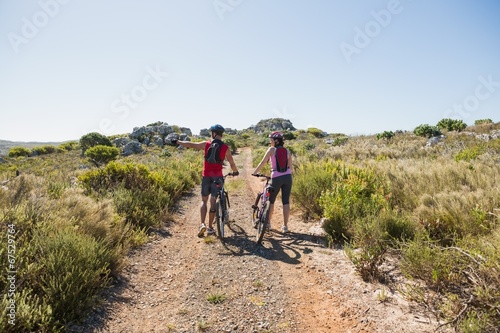 Active couple cycling in the countryside looking to the side