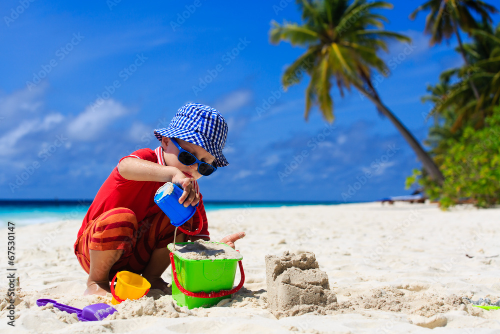 child building sand castle on tropical beach child building sand castle on tropical beach