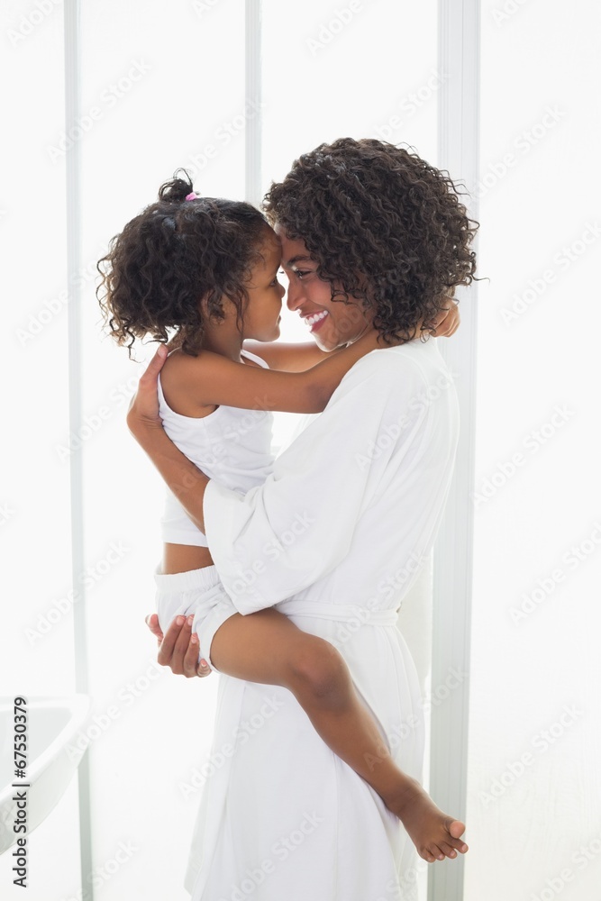 Pretty mother picking up her daughter and hugging her