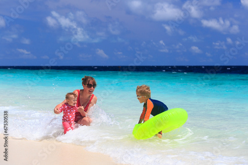 mother with kids swimming on sea vacation