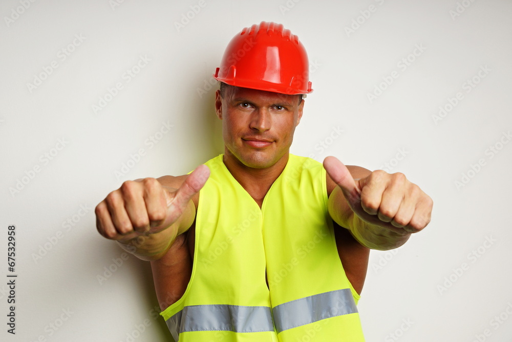 Muscular worker at protective helmet shows with fingers on you Muscular worker at protective helmet shows with fingers on you