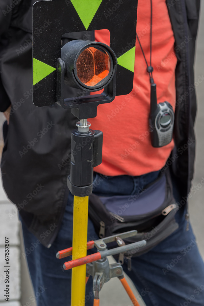 theodolite prism with survey worker in background theodolite prism with survey worker in background