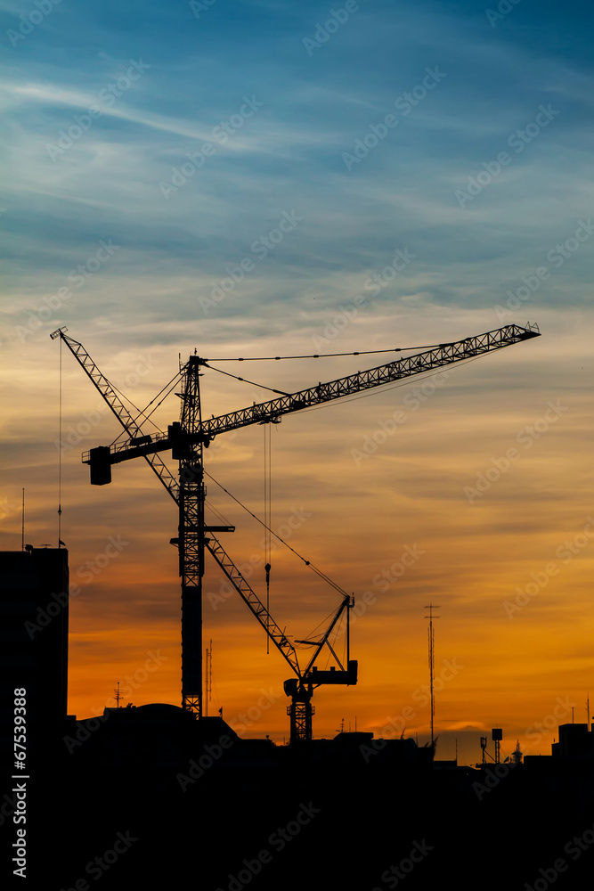 Silhouettes of construction crane in the colorful sky