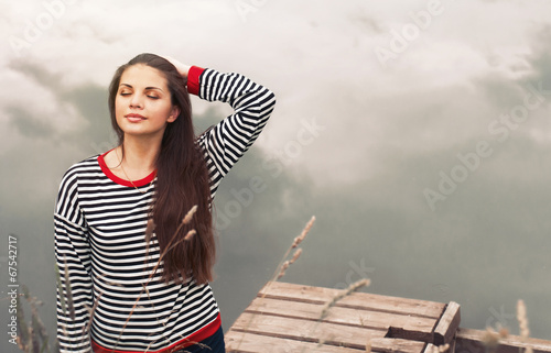 cute attractive young woman enjoying harmony of nature on pier n