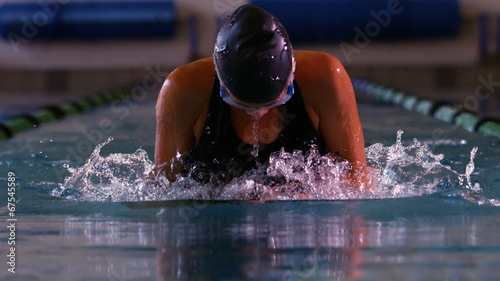Fit swimmer doing the breast stroke in swimming pool