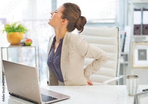 Portrait of business woman with back pain in office photo