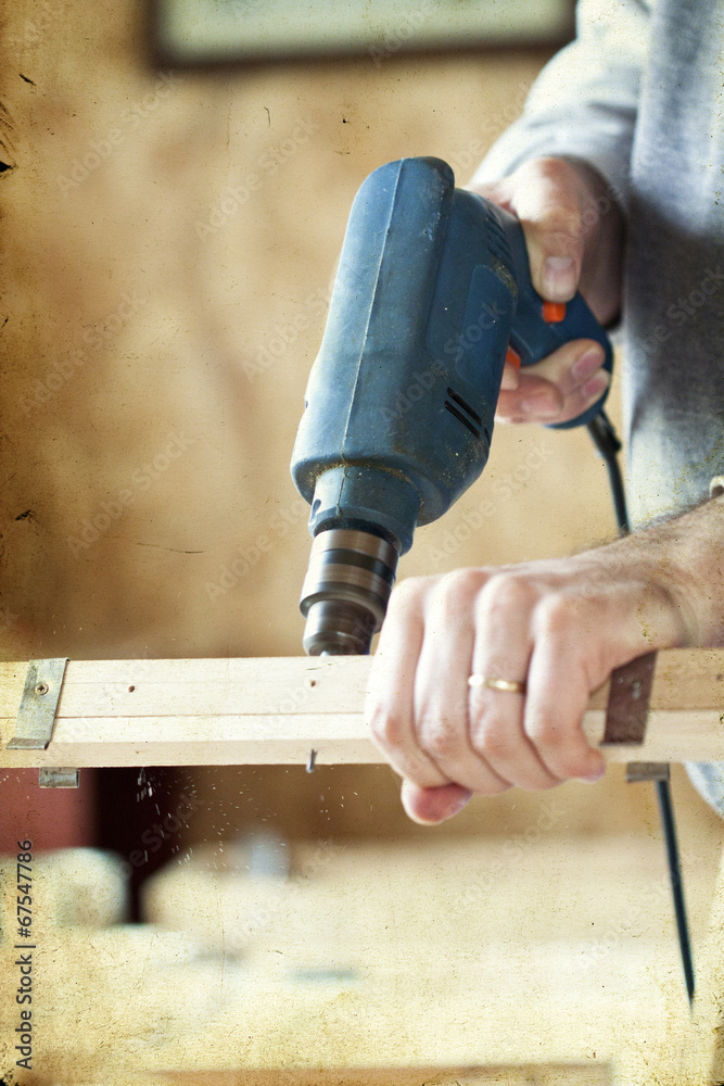 Man's arms drill lath in the workshop