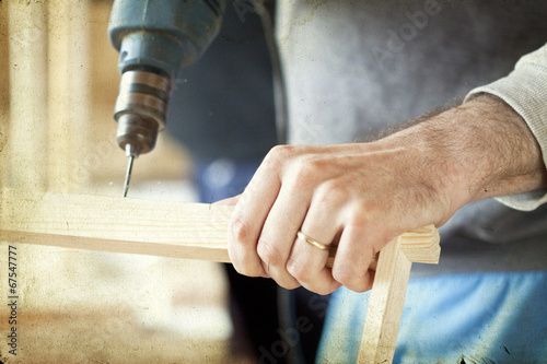 Man's arms drill lath in the workshop