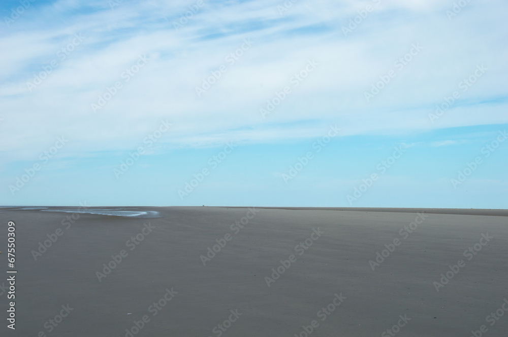 Picture of an empty outstretched beach when its ebb with a blue sky on Schiermonnikoog in the Netherlands