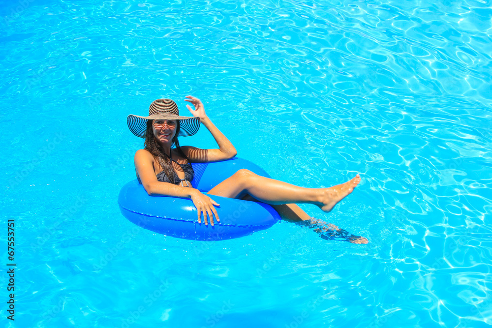 Young woman wearing a straw hat at the pool