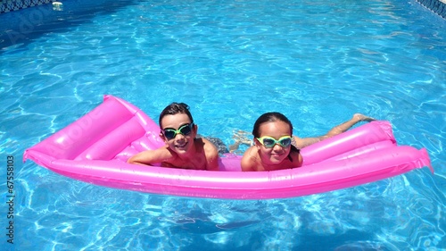 Bild auf Leinwand Niños en la piscina sobre colchoneta