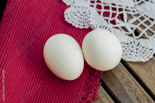 Two white Eggs isolated on wooden table. photo