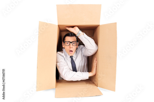 Fotografi Young businessman trapped in a box