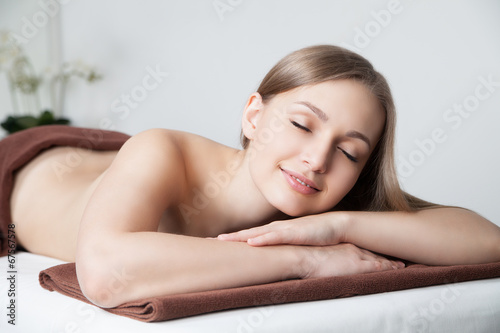 woman in spa salon lying on massage desk