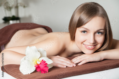 woman in spa salon lying on massage desk