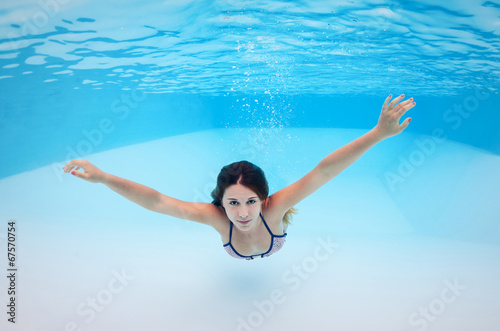 Underwater woman portrait in swimming pool.