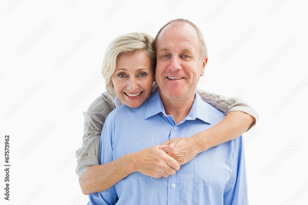 Happy mature couple embracing smiling at camera Happy mature couple embracing smiling at camera