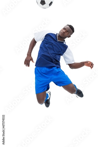 Football player in blue heading ball © WavebreakMediaMicro