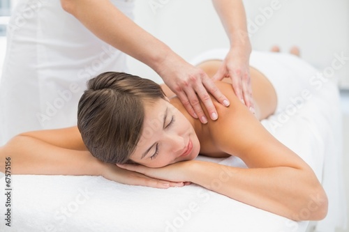 Attractive woman receiving shoulder massage at spa center