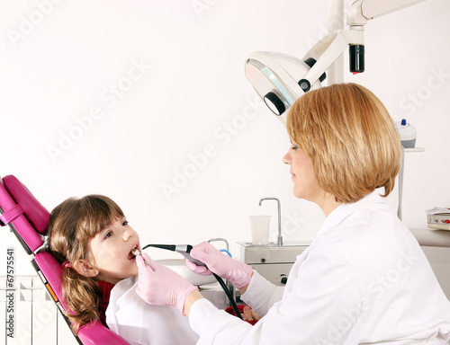 female dentist and little girl patient in dental office