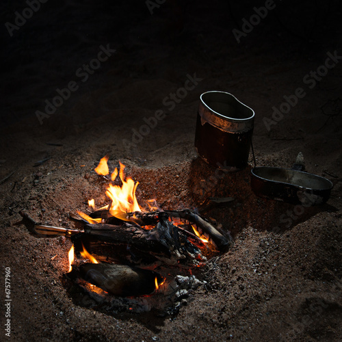 Pot near campfire at night.