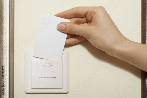 Hotel keycard - Female hand puts keycard into switch.