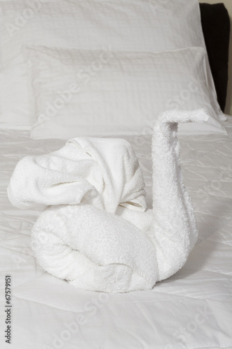 Towel swan - Swan made from towels on bed .