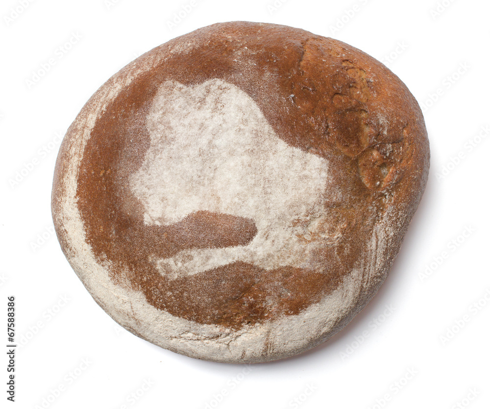 A loaf of fresh bread covered with rye flour in the shape of Sen A loaf of fresh bread covered with rye flour in the shape of Sen