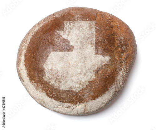 A loaf of fresh bread covered with rye flour in the shape of Gua
