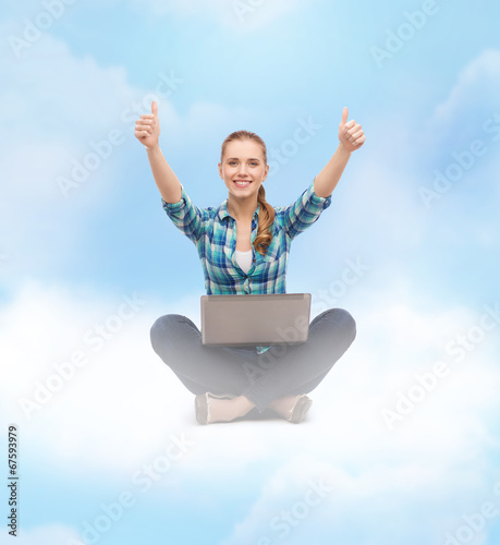 smiling woman with laptop and showing thumbs up © Syda Productions
