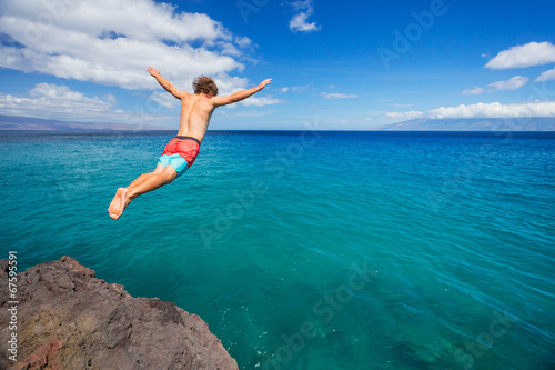 Fotografie, Obraz Man jumping off cliff into the ocean