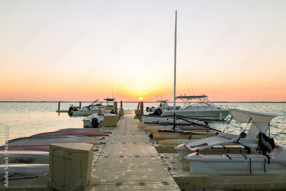 boats moored to pier at sundown