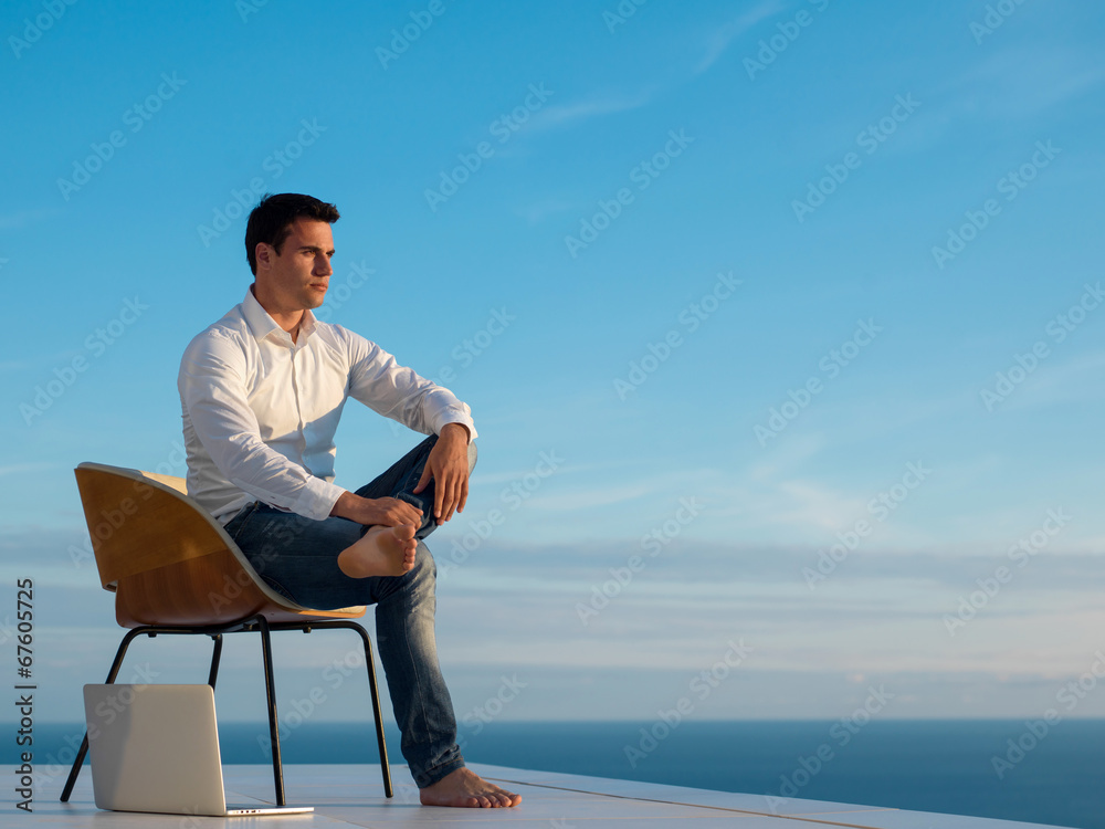 relaxed young man at home on balcony