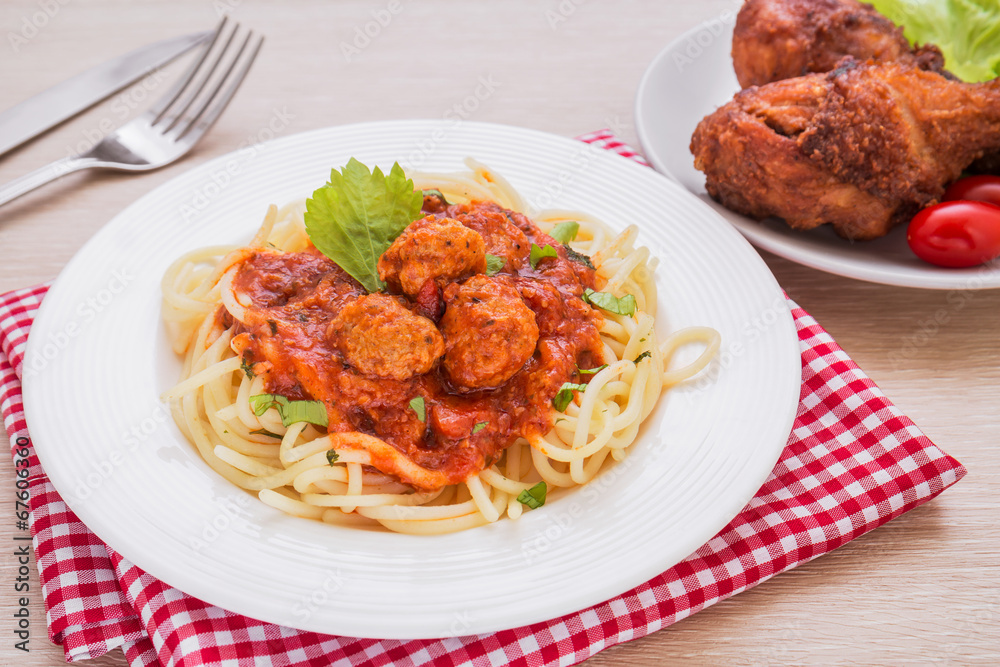 Spaghetti with meatballs in tomato sauce and deep fried chicken