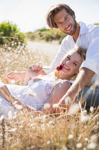 Attractive couple relaxing in the countryside smiling at camera