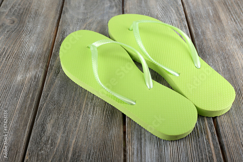 Colorful flip-flops on wooden background