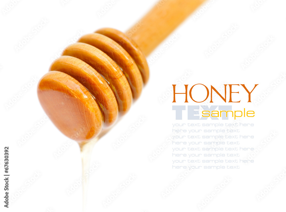 Honey dripping from a wooden dipper isolated on a white backgrou Honey dripping from a wooden dipper isolated on a white backgrou