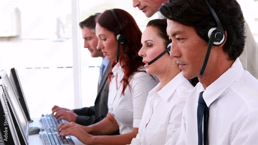 Call centre agents working and talking on headsets Call centre agents working and talking on headsets