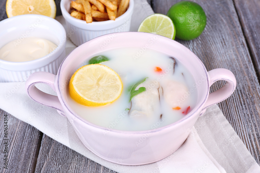 Tasty soup with oysters on wooden table Tasty soup with oysters on wooden table